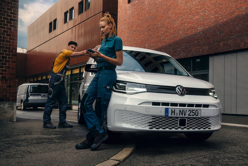 Un hombre y una mujer junto a un VW Caddy Cargo