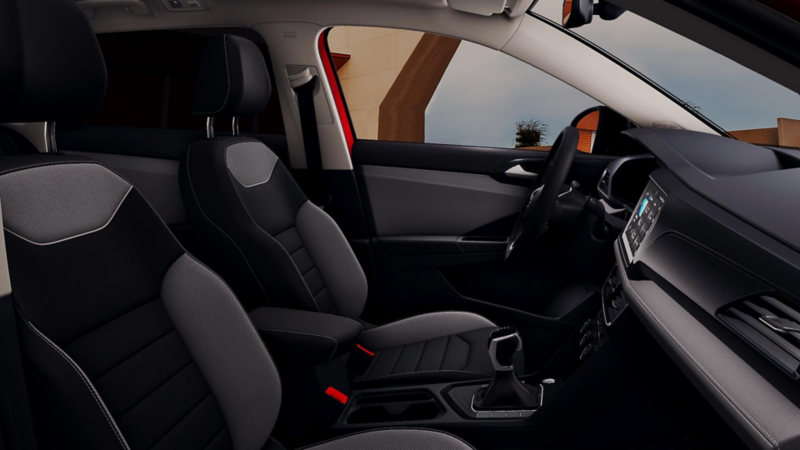 Interior de Taos VW con asientos bicolor, pantalla táctil y volante deportivo.
