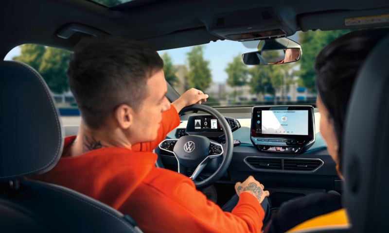 Fahrer nutzt Sprachbedienung im VW ID.3 und steuert damit verschiedene Funktionen.