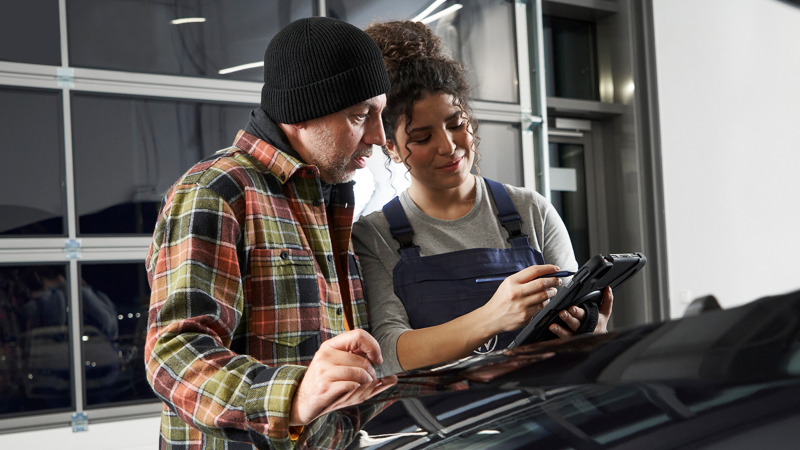 Una mujer del servicio técnico de VW hablando con un hombre.