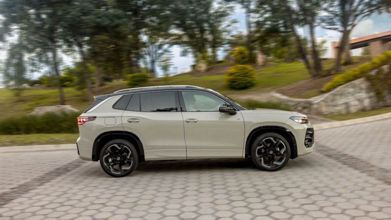 Camioneta SUV de Volkswagen color blanco transita sobre calle adoquinada en fraccionamiento.