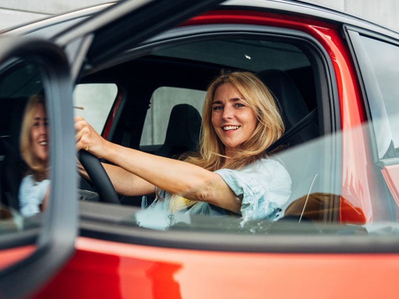 Woman in Volkswagen vehicle looking out window.