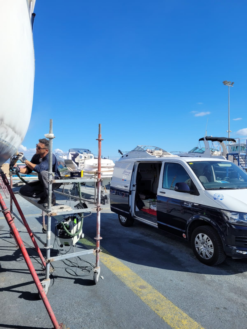 Un hombre trabajando en el puerto junto a furgoneta commerce de VW.