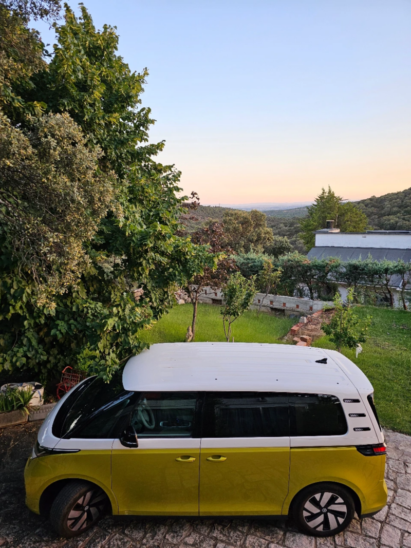 Un VW ID. Buzz amarillo aparcado en un jardín verde.