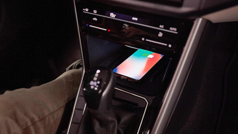 Teléfono con pantalla encendida en el cargador inalámbrico de la consola central de Volkswagen Virtus.