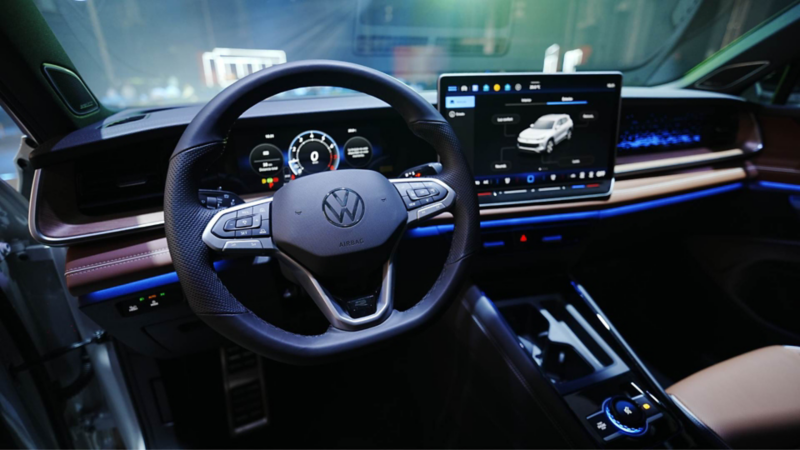 Interior de Nuevo Tiguan 2025 con volante multifunciones y pantalla flotante. 
