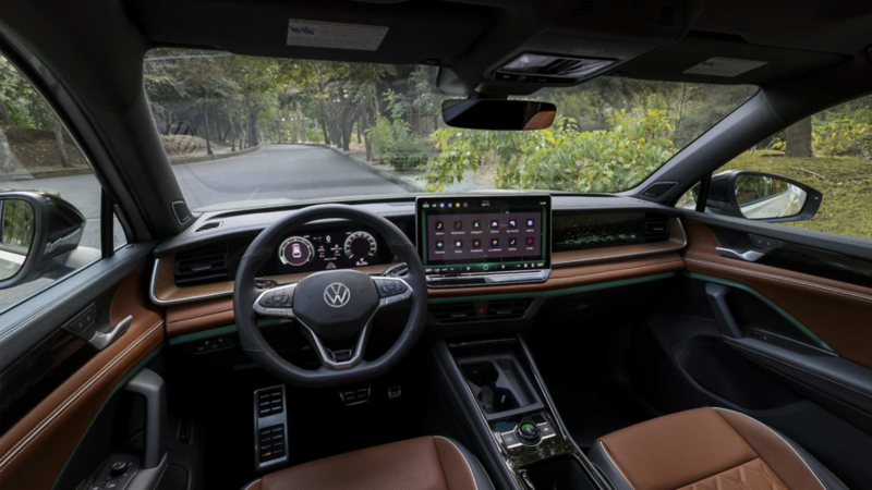 Interior de Nuevo Tiguan con pantalla flotante táctil, asientos, panel central y acabados bitono.