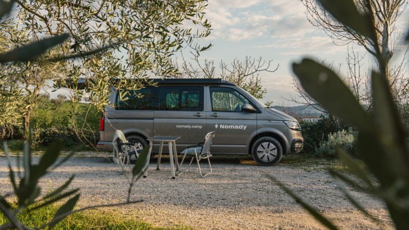 Il VW Agribus si trova nella natura con un tavolo vuoto davanti a sé.