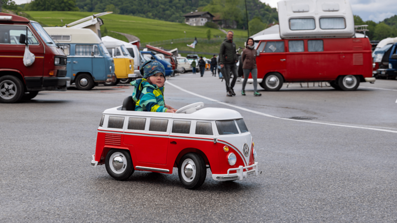 Un bambino guida un mini VW T1 nell’area del raduno Bulli.