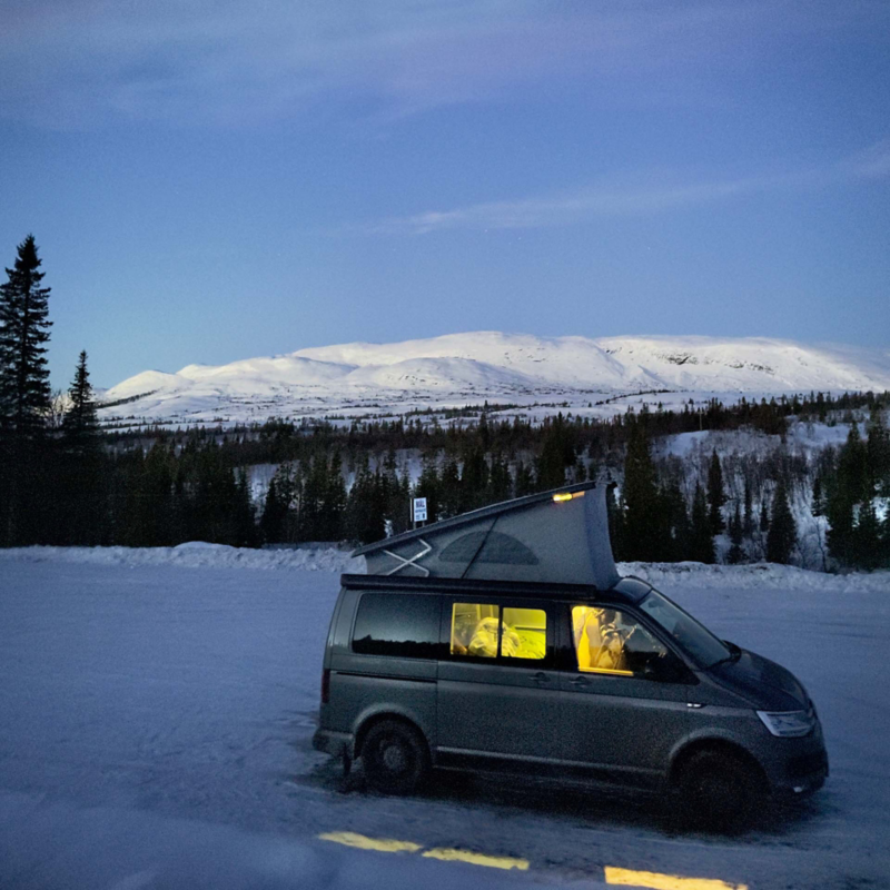 VW California med popup-tack i vintermiljö