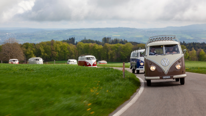 Mehrere VW Bullis fahren auf einer Passstrasse