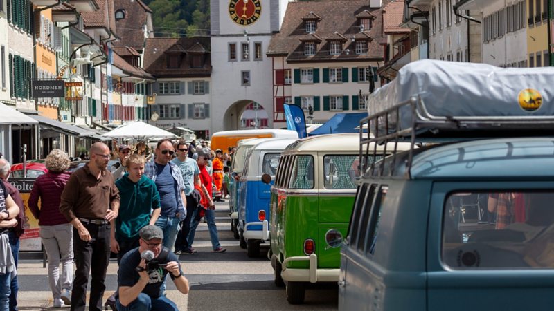Bild von mehreren VW Bullis in einem Dorf