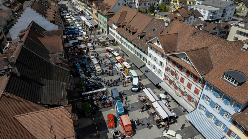 Bild von mehreren VW Bullis in einem Dorf