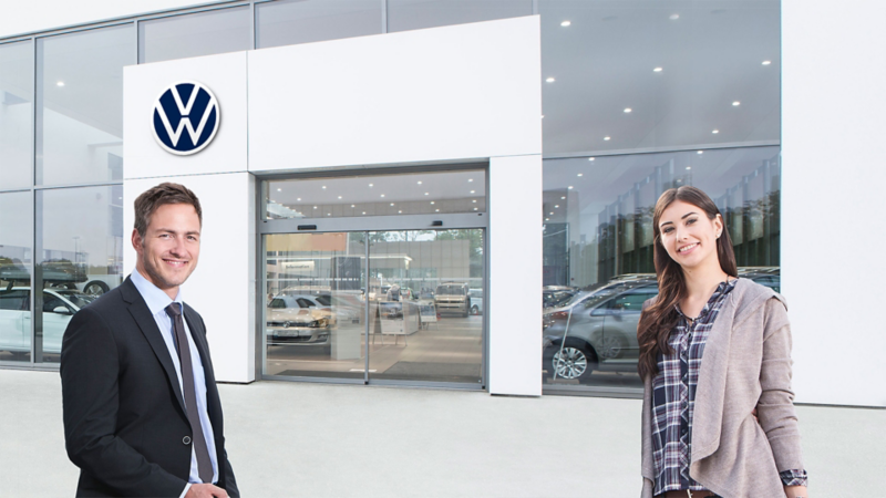Eine Frau und ein Mann vor einem Volkswagen Autohaus
