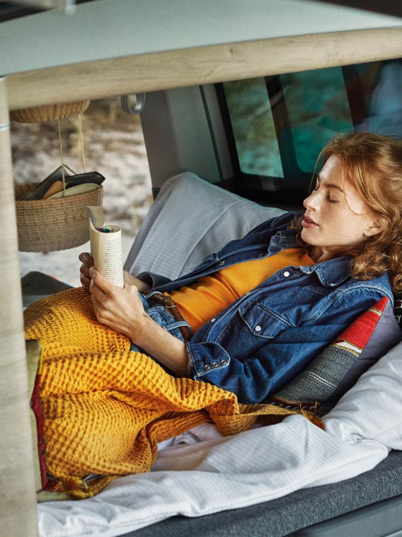 Kvinna läser i en VW California 6.1