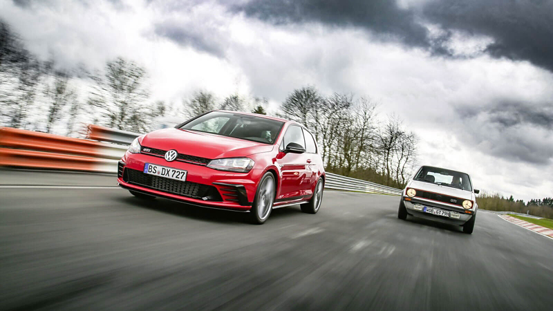 La Golf 7 GTI et la toute première génération de Golf GTI, roulent sur un circuit, de face.