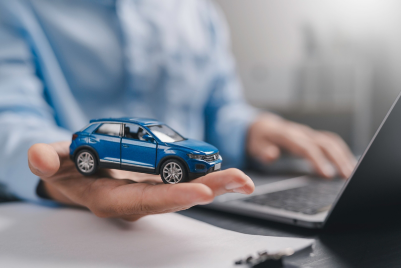 Przedstawiciel handlowy trzymający na dłoni miniaturkę samochodu Volkswagena