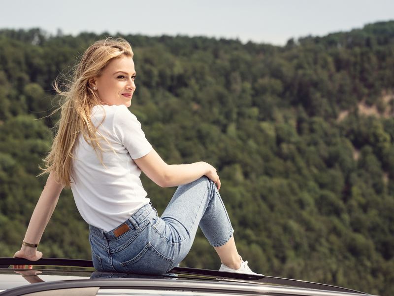 Femme assise sur le toit d'une VW