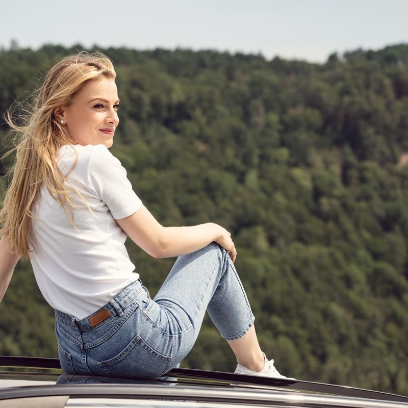 Femme assise sur le toit d'une VW