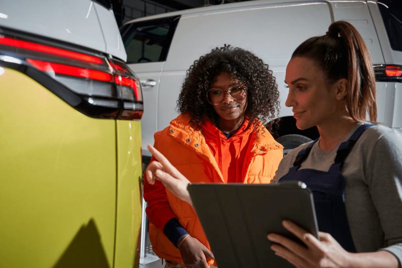 Un employé du service de réparation carrosserie discute avec une cliente