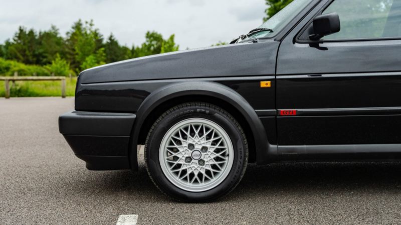 A side profile shot of a black Mk 2 VW Golf showing GTI logo and wheel
