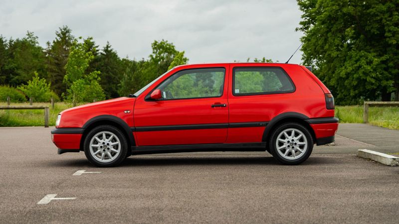 A side profile shot of a red Mk3 VW Golf GTI