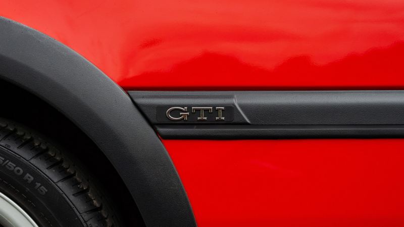 A side profile shot of a red Mk3 VW Golf showing GTI logo