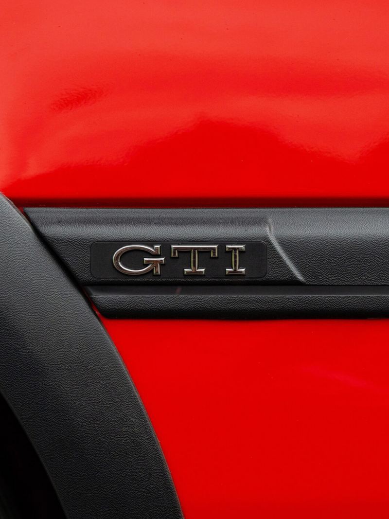 A side profile shot of a red Mk3 VW Golf showing GTI logo