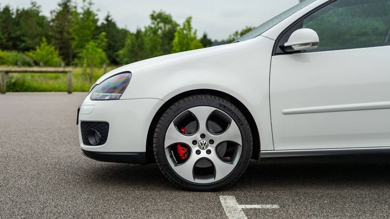 A side profile shot of a white Mk 5 VW Golf GTI focussing on the wheel