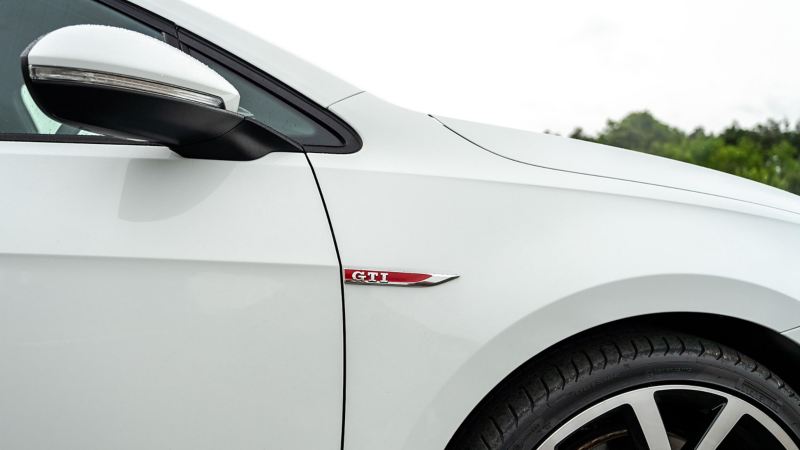 A side profile shot of a white Mk 7 VW Golf showing GTI logo and wing mirror 