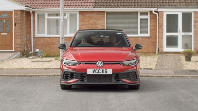 Chandrin and Ruwani sit inside a red 45th anniversary Golf GTI