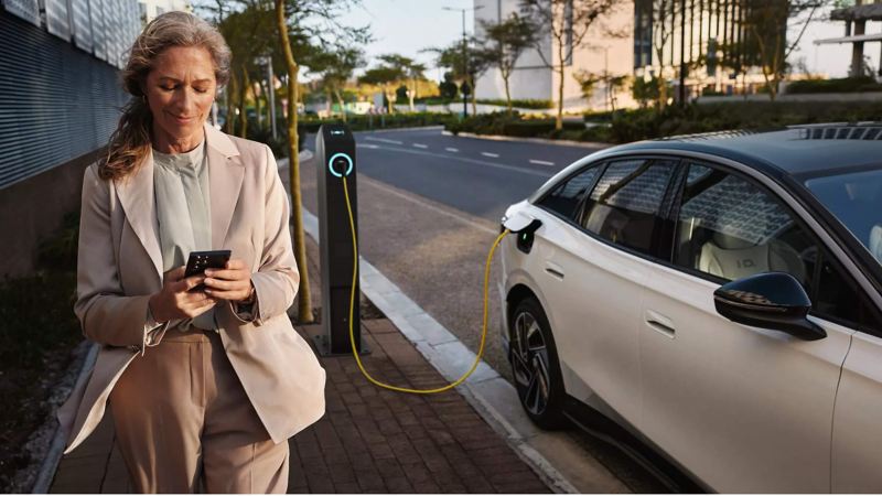 Woman standing next to the VW electric car
