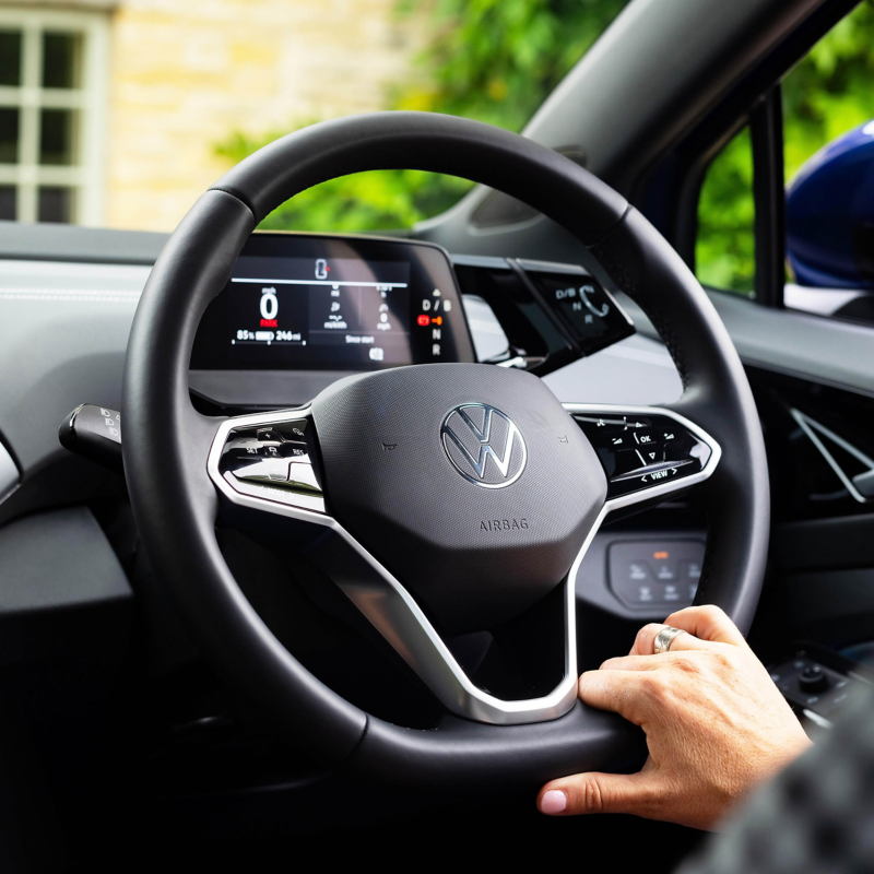 a close up of a hand on a VW steering wheel