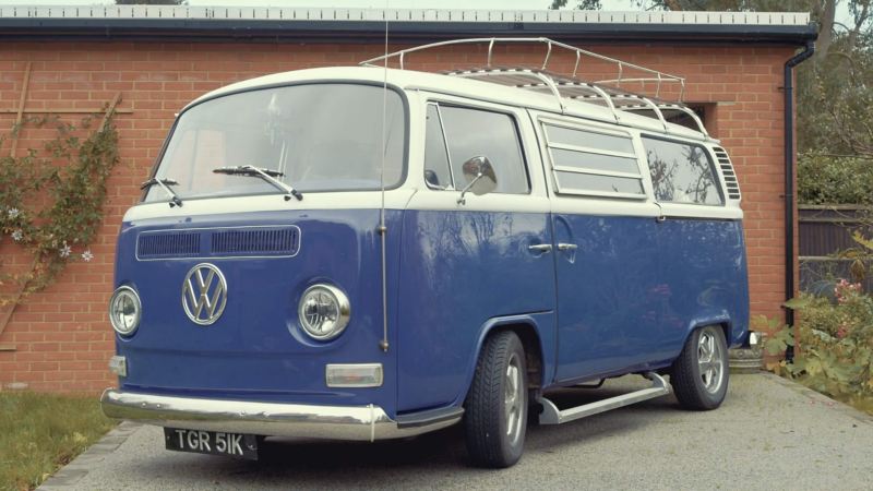 A photo showing a blue and white coloured classic Volkswagen campervan.