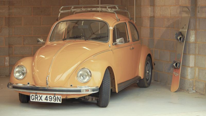 A Volkswagen Beetle parked in a garage. 