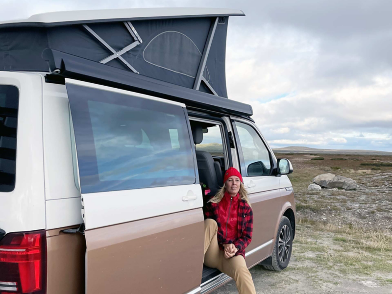 Lina Skandevall sitter i skjutdörren på sin VW California Ocean.