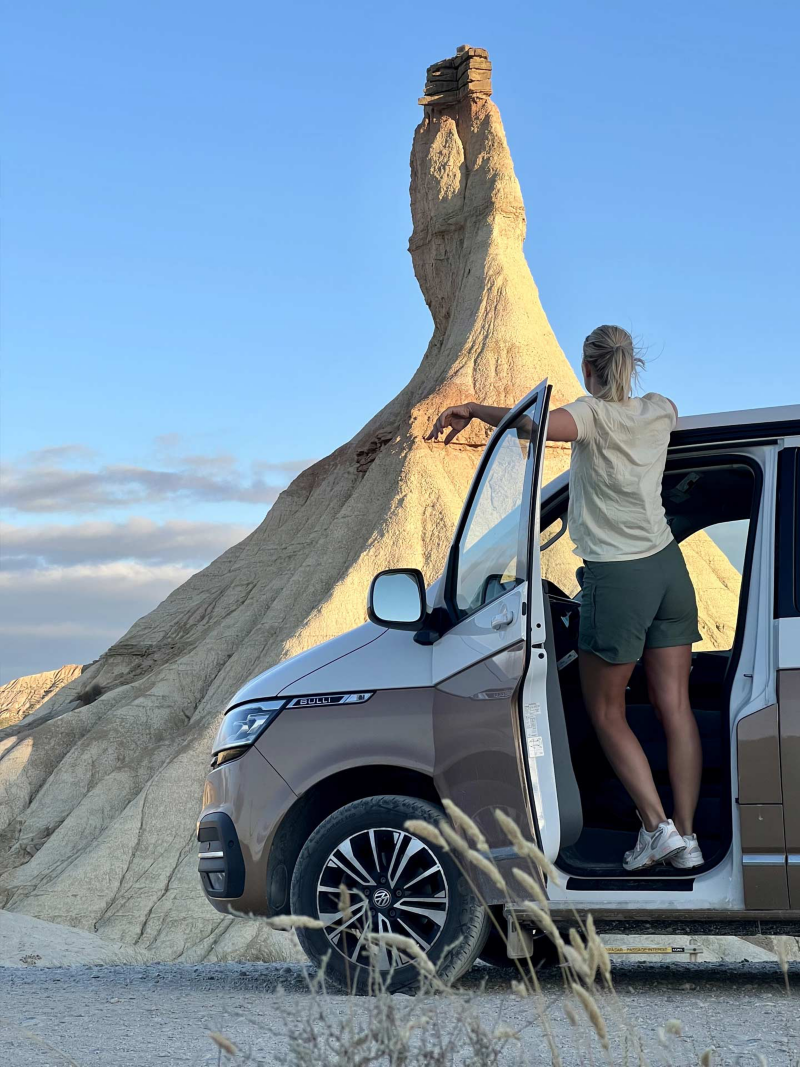 Lina Skandevall i sin VW California Ocean framför ett naturfenomen.