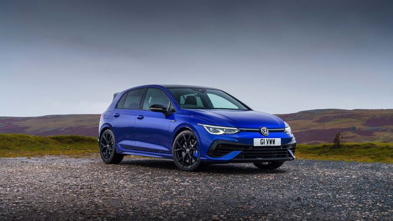 The new Golf R Line parked against a countryside landscape.