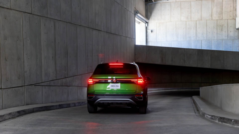 Taos de Volkswagen verde por la parte trasera en una rampa de concreto, con las calaveras encendidas.