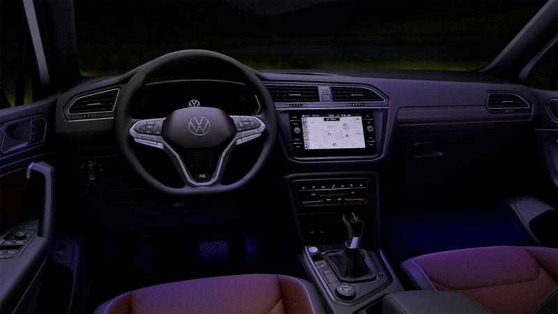 Interior de Tiguan 2023, con vistas a panel de control con volante multifuncional, pantallas y palanca.