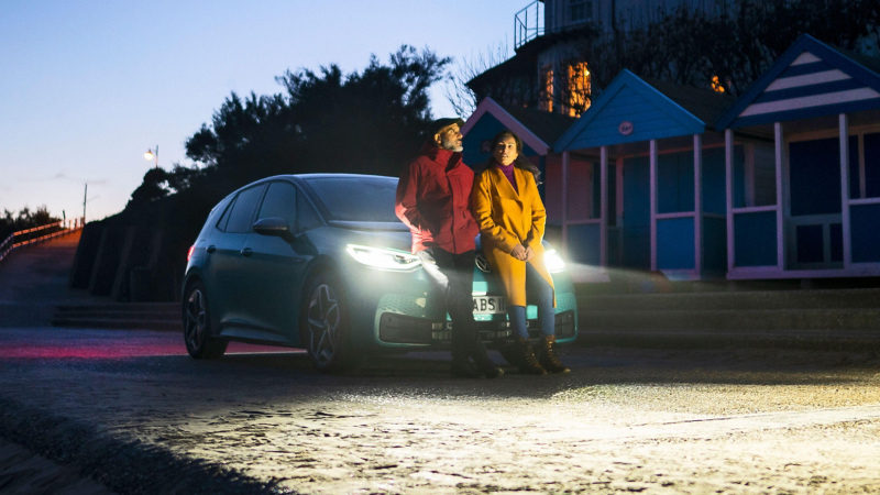 A couple sitting on the bonnet of an ID.3