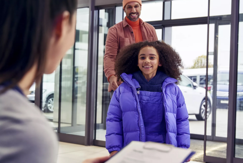 Young girl with her father in a Volkswagen dealership.