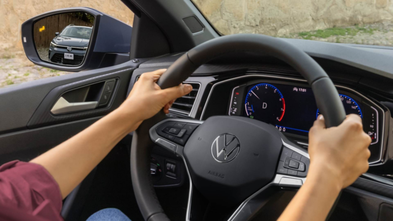 Conductor al volante de un Volkswagen observa el tablero con precaución mientras el testigo EPC permanece encendido