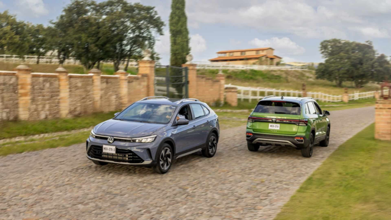 Camionetas Nivus y Taos de Volkswagen avanzan por camino empedrado.
