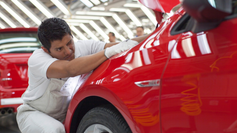 Trabajador puliendo pintura de automóvil en planta Volkswagen de México