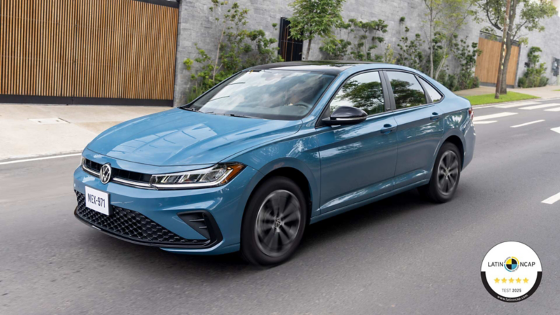Jetta 2025 en color azul transita en una avenida dentro de un residencial.