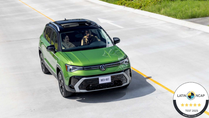 Camioneta Taos 2026 de color verde y techo color negro circula sobre avenida con franja amarilla.