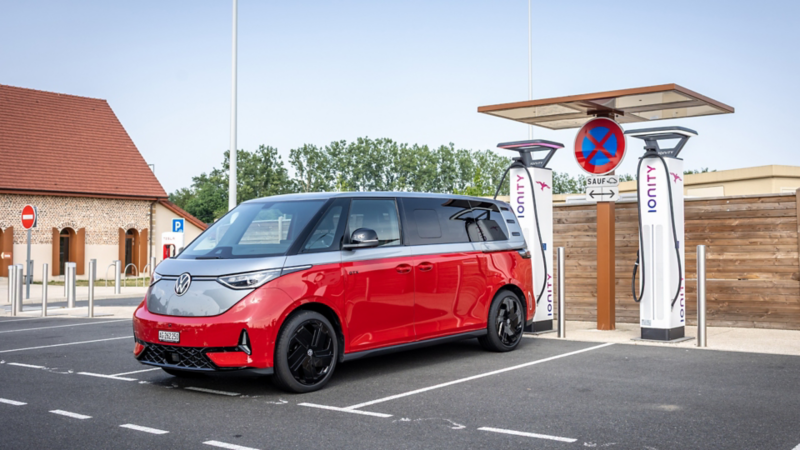 Ein roter VW ID. Buzz steht seitlich an einer IONITY-Schnellladestation angeschlossen.