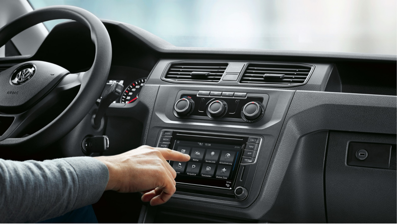 A man uses the navigation system in a stationary vehicle.