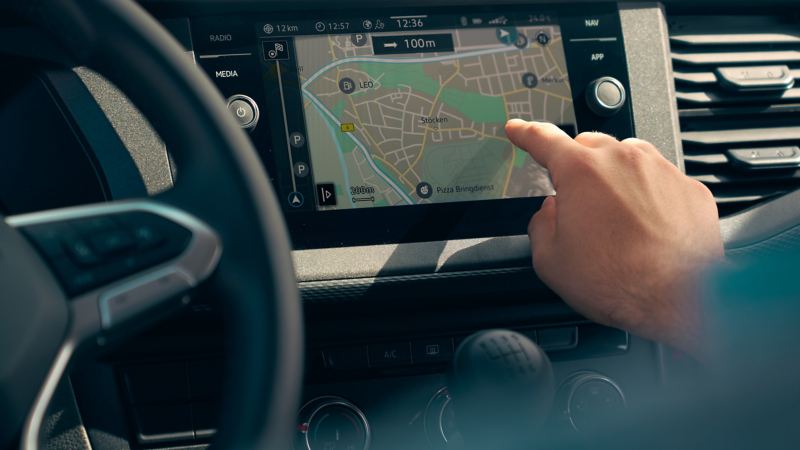 Ett finger pekar på infotainmentsystemet och WeConnect i en VW transporter